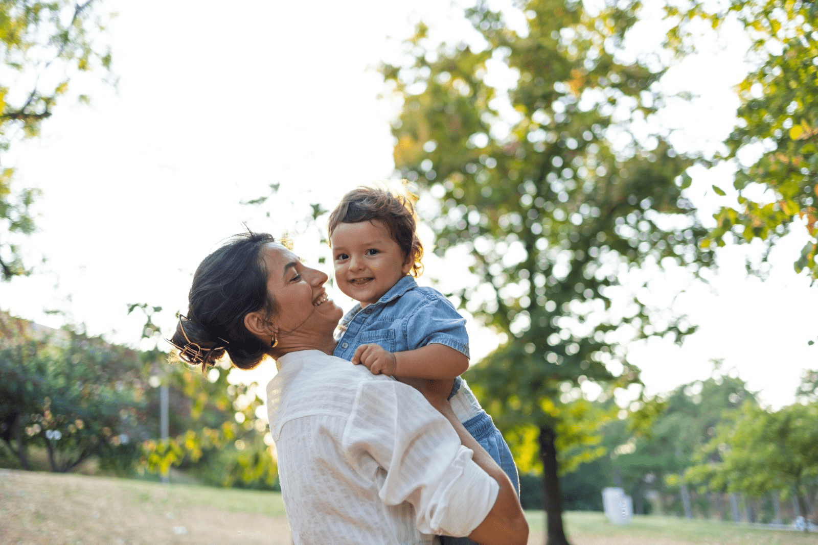 A mother holds her child, smiling broadly, showcasing the happiness and enhanced well-being that cosmetic procedures can bring.