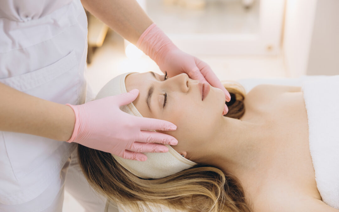Cosmetic professional performing facial massage on relaxed client