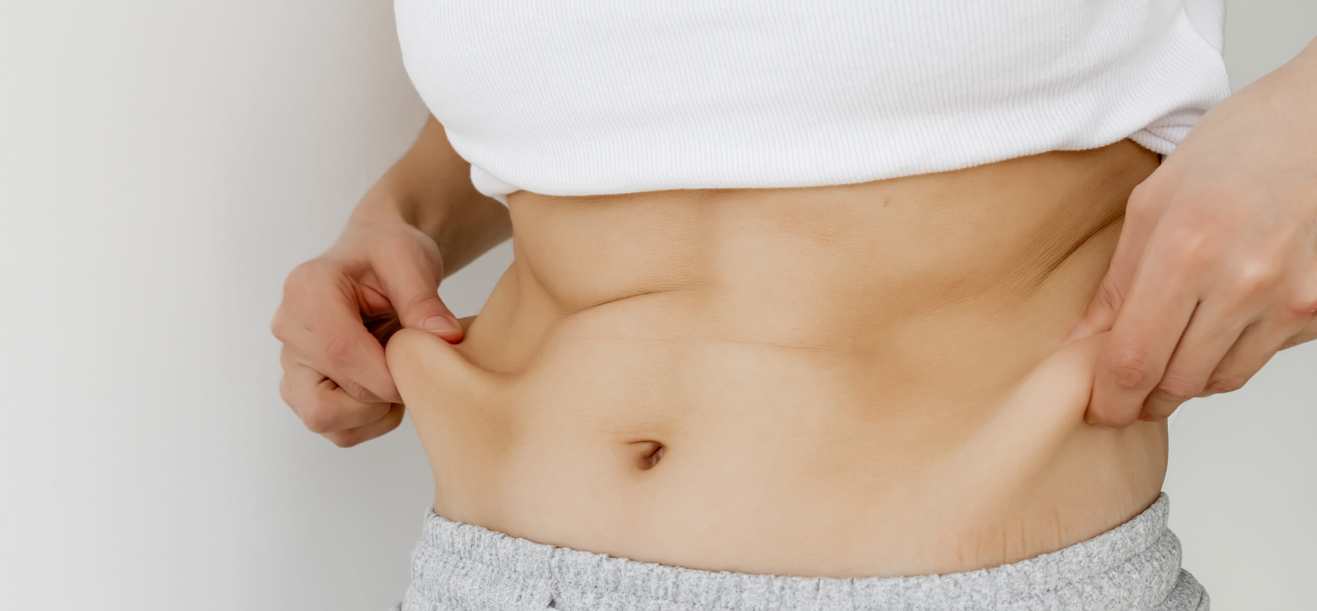 Female checking abdominal skin after weight loss